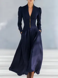 Detailed view of an elegant navy blue V-neck maxi dress featuring gold buttons and pockets