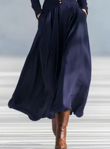 Close-up of elegant navy blue maxi dress with a flowing skirt and pleated details