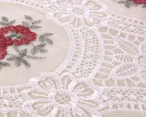 Primo piano di ricamo floreale in filato di vetro bianco per tovaglia o copri-tutto. (84 chars)