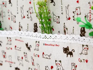 Primer plano de estampado de gatos y encaje blanco en funda de tela para refrigerador