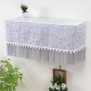 Vista dettagliata della copertura per condizionatore a muro con eleganti pompon.