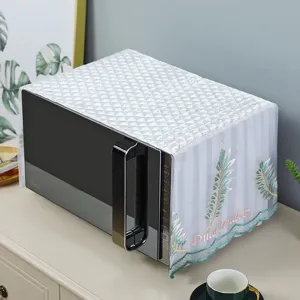Close-up of white lace microwave dust cover with quilted top and green leaf embroidery