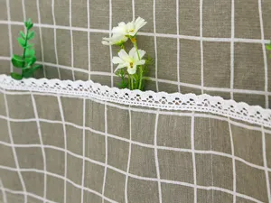 Primer plano de funda de nevera a cuadros verdes con un delicado borde de encaje blanco