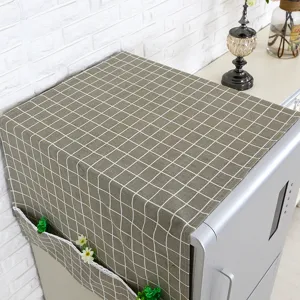 Detalle de funda para nevera gris a cuadros con bolsillos laterales y ribete de encaje