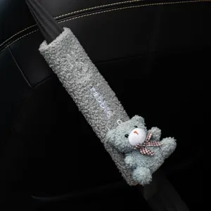 Detail view of plush gray car seatbelt cover with cute teddy bear and embroidery