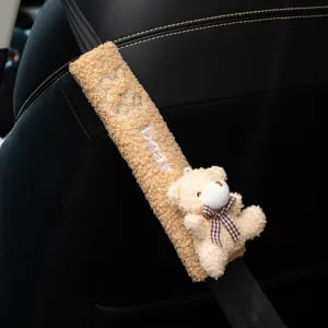 Detail of cute plush bear car seat belt cover with soft fleece texture and embroidered bear text