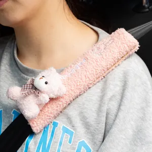 Primer plano de una funda de cinturón de coche de felpa rosa con un tierno osito 3D.