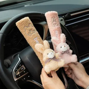Close-up of cute plush bear and rabbit car seat belt covers in a car