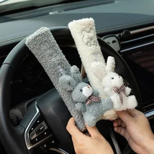 Close-up of cute plush rabbit and bear seat belt covers with soft texture and bows