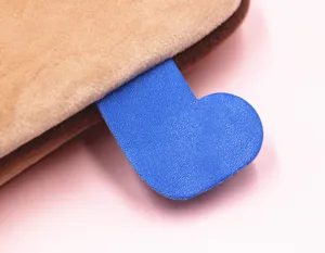 Dettaglio dell'etichetta blu a forma di cuore sulla custodia per iPad in morbido peluche