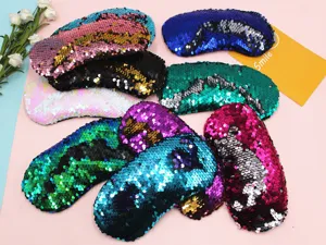 Close-up detail showing various colorful reversible mermaid sequin sleep masks for travel