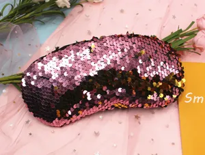Close-up detail of a pink reversible mermaid sequin sleep eye mask for travel and relaxation