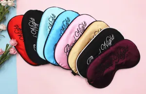 Nahaufnahme von Satin-Schlafmasken mit „Good Night“-Stickerei in verschiedenen Farben.