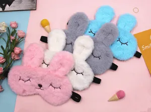 Detailed view of cute plush rabbit sleep masks in pink, white, grey, and blue soft materials.