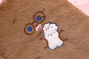 Close-up of a soft brown plush iPad sleeve featuring a cute embroidered bear and rabbits