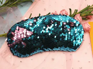 Detail macro view of reversible mermaid sequins in teal and pink on travel eye mask.
