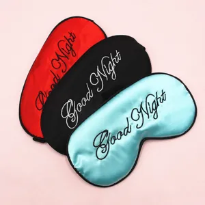 Nahaufnahme von drei Satin-Schlafmasken mit Good Night-Stickerei in verschiedenen Farben