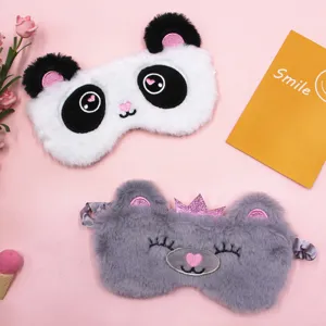 Close-up detail of soft plush panda and grey crown bear sleep masks on a pink surface