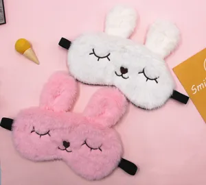 Close-up of pink and white plush bunny sleeping eye masks with cute embroidery details