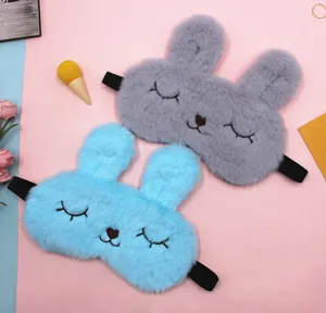 Detail showing gray and blue plush rabbit sleep masks with cute closed-eye embroidery.