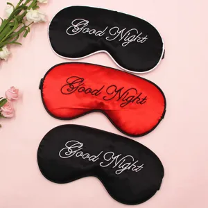 Nahaufnahme von drei Schlafmasken aus Satin mit Good Night Stickerei in Rot und Schwarz