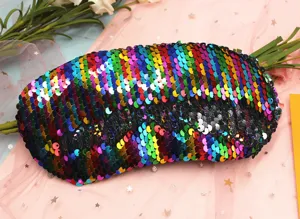 Dettaglio macro delle vivaci paillettes arcobaleno reversibili su una maschera da notte sirena