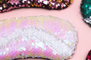 Primo piano dei dettagli delle paillettes reversibili sulla maschera da viaggio sirena