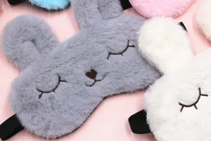 Close-up detail of soft plush rabbit sleep masks with cute embroidered sleeping eyes.