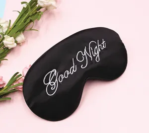 Detail der schwarzen Satin-Schlafmaske mit Good Night-Stickerei zur Verdunkelung