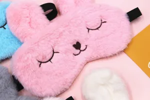 Close-up of cute plush bunny sleep mask with soft fur and embroidered face detail