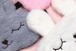 Close-up of soft plush bunny sleep masks in various colors with cute embroidery