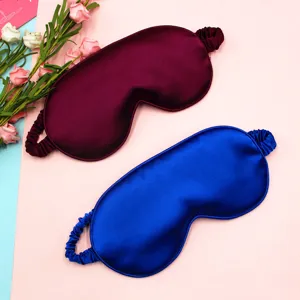 Detail of silk-like sleep eye masks in maroon and royal blue with glossy finish
