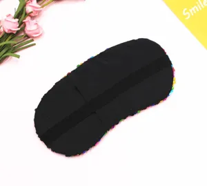 Dettaglio del retro nero morbido e della fascia elastica di una maschera per occhi in paillettes.