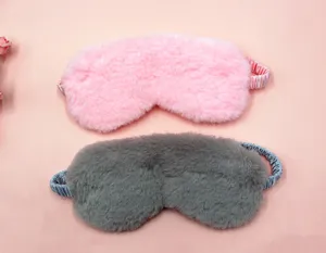 Close-up detail of soft pink and grey plush sleep eye masks with fuzzy rabbit fur texture