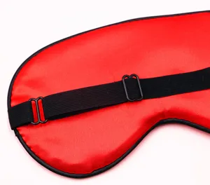 Nahaufnahme einer roten Satin-Schlafmaske mit verstellbarem schwarzem Gummiband.
