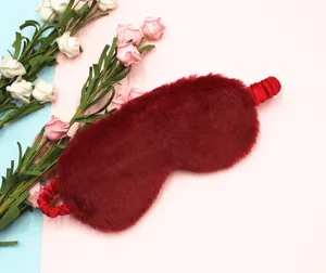 Close-up detail of soft wine red plush faux fur eye mask with an elastic satin strap