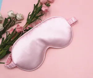 Detailed macro view of smooth pink silk sleep mask showing high-quality satin texture