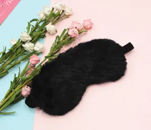 Close-up of fluffy black plush sleep mask with soft texture and elastic strap