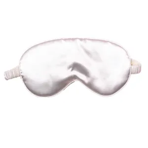 Detail view of a pale pink faux silk sleep mask showing satin texture and elastic strap