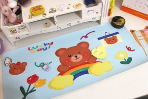 Detailansicht des süßen Bären- und Regenbogen-Designs auf einer blauen Tischmatte.