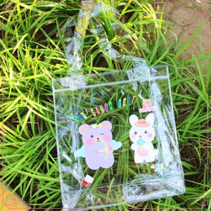Primo piano di una borsa in PVC trasparente con illustrazioni di orso e coniglio sull'erba.
