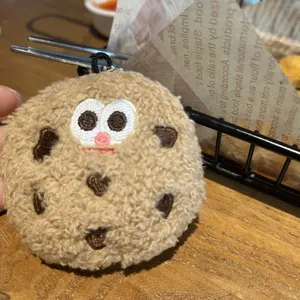 Close-up of a cute plush cookie-shaped keychain charm with embroidered facial features