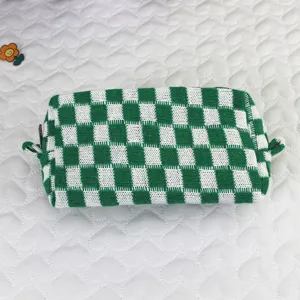 Detalle de neceser de punto a cuadros verdes y blancos con una textura suave