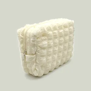 Close-up of the textured cream bubble grid pattern on a soft cosmetic storage bag