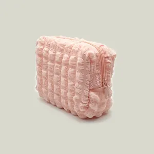 Close-up shot of soft pink bubble grid textured cosmetic pouch with zipper detail