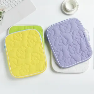 Custodie trapuntate per tablet con fiori in giallo e viola su una scrivania bianca