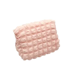 Light pink popcorn grid makeup bag with soft textured fabric for cosmetic storage