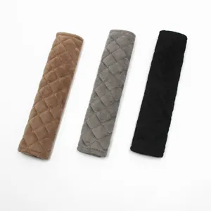 Detailed view of quilted plush seat belt shoulder pads in brown, grey, and black.