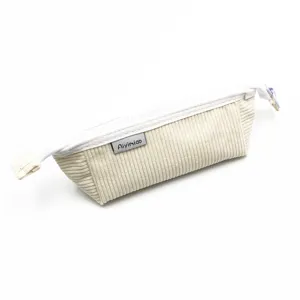 Dettaglio ravvicinato di un astuccio in velluto a coste color crema con cerniera e etichetta