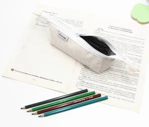 Primo piano di un astuccio minimalista in velluto a coste bianco crema con zip aperta